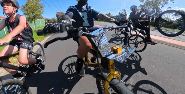 Rider mid-ride on a custom bike along a shared path