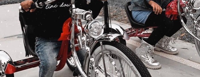 Rider stepping over a red and chrome custom lowrider bicycle