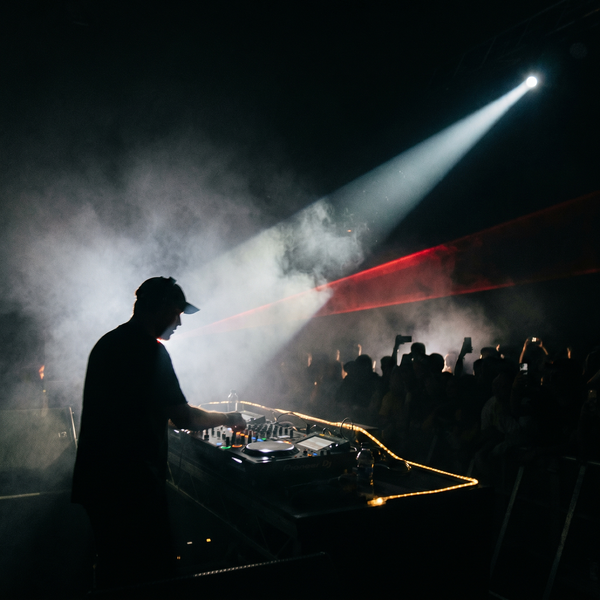 DJ working a smoke-filled room under a single beam of light