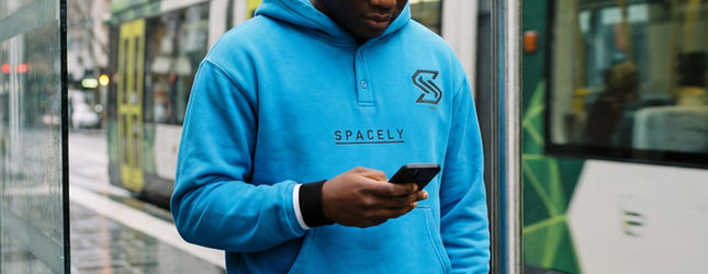Man in a blue Spacely hoodie on a Melbourne tram platform