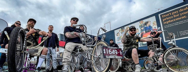 Low Ballers Mafia crew and their bikes lined up outside a warehouse