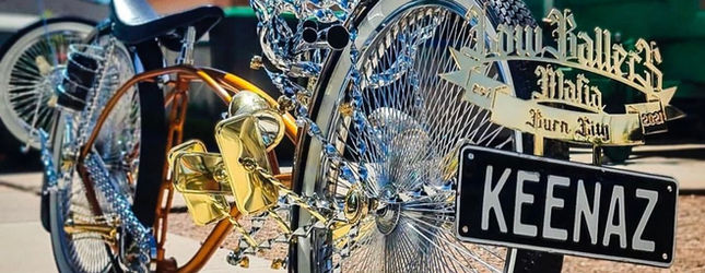 Gold engraved lowrider parts beside a custom KEENAZ number plate