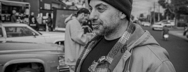Black and white portrait of a man in a beanie at the car show