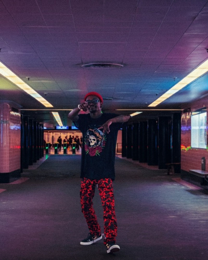 Person in Spacely print trousers standing in a lit underpass
