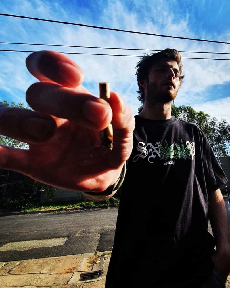 Two people outdoors in Spacely tees, one reaching toward the camera
