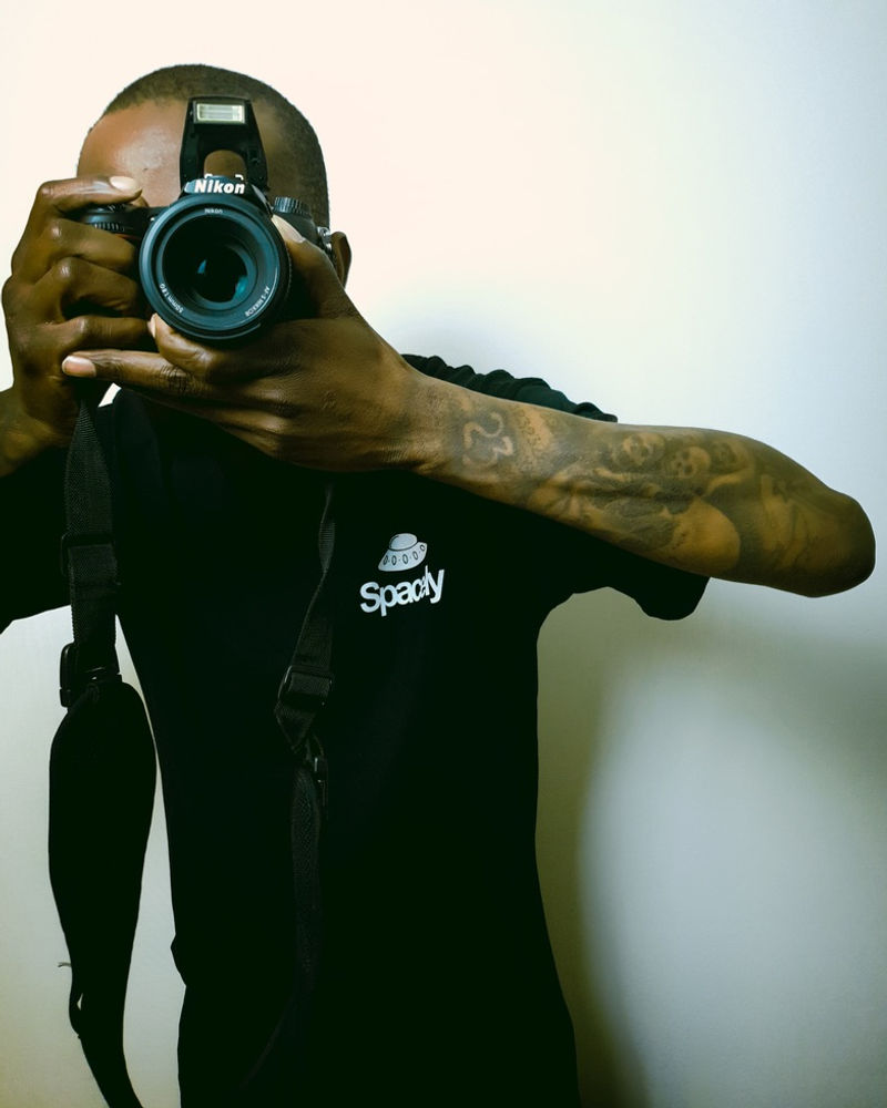 Person in a Spacely jacket holding a camera to their eye