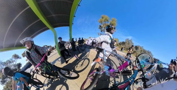 Wide-angle shot of riders circled up at a bike meet
