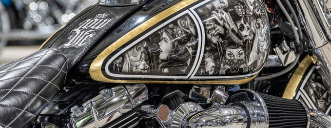 Close-up of the engraved chrome and gold frame on a custom lowrider bicycle