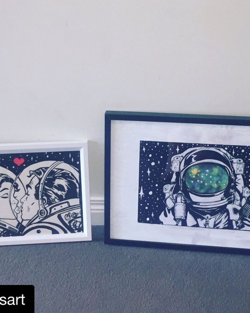 Framed Spacely astronaut artwork prints on a wall