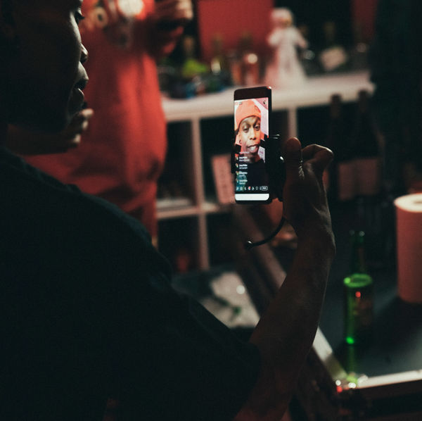 Filming a phone screen in a red-lit studio