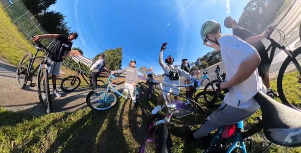 Riders posted up on the grass with their bikes