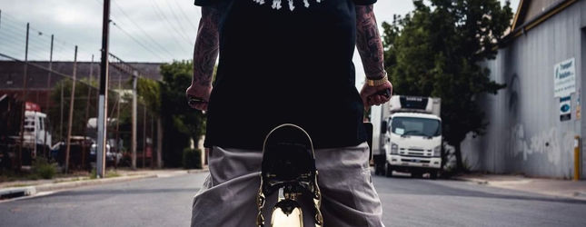 Rider seen from behind on a lowrider bicycle on an industrial back street