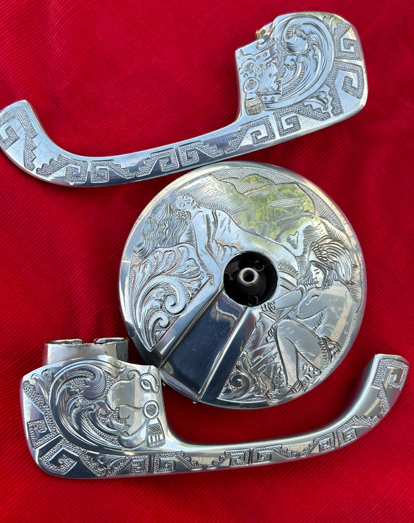Engraved chrome motorcycle parts arranged on red velvet