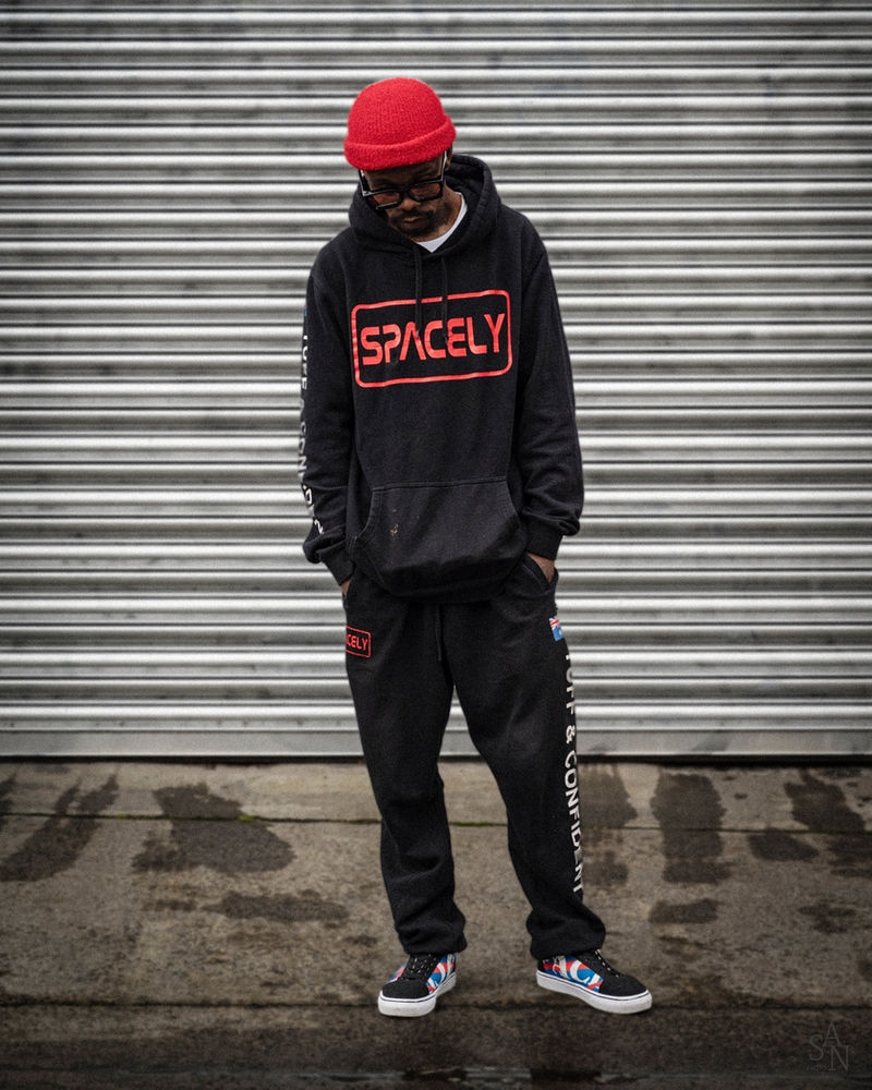 Person in a Spacely hoodie in front of a roller shutter