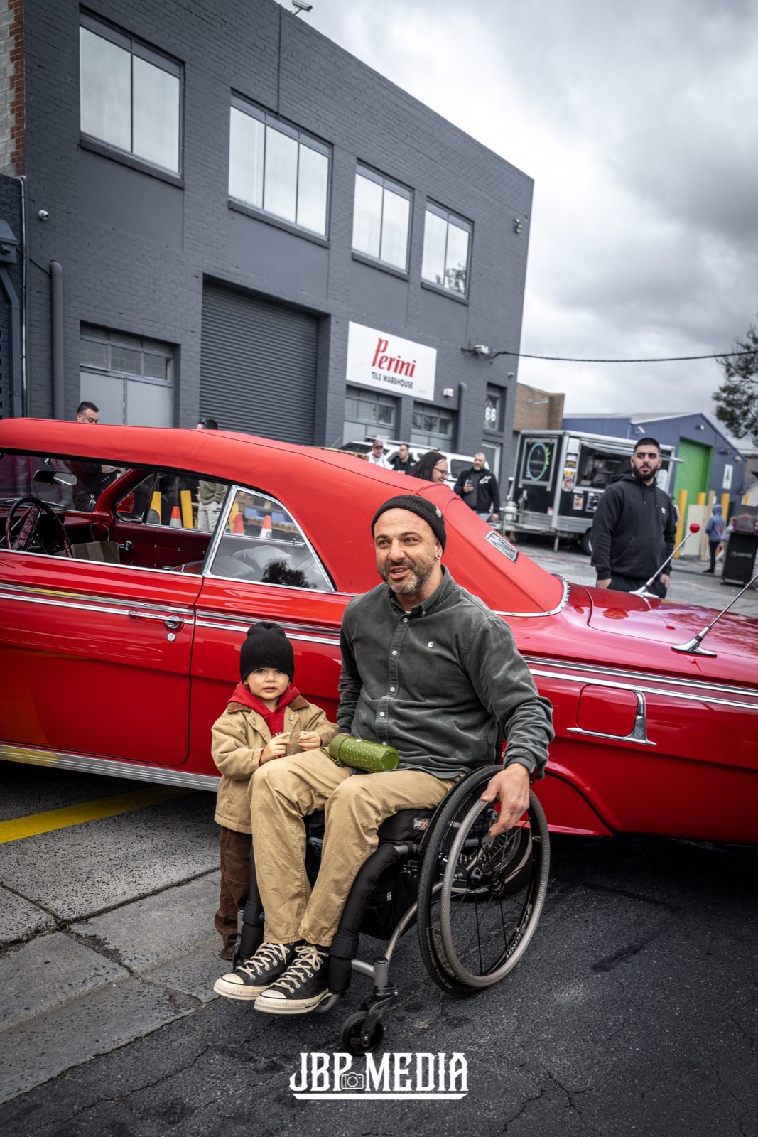 A father and his son beside a red Impala convertible at the Lowrider Cars & Coffee, Melbourne. Photo: JBP Media