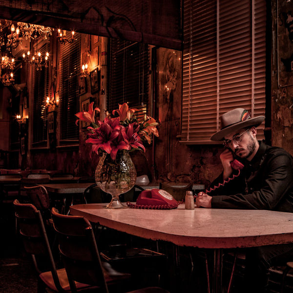 Portrait of a man in a wide-brimmed hat in an ornate bar interior