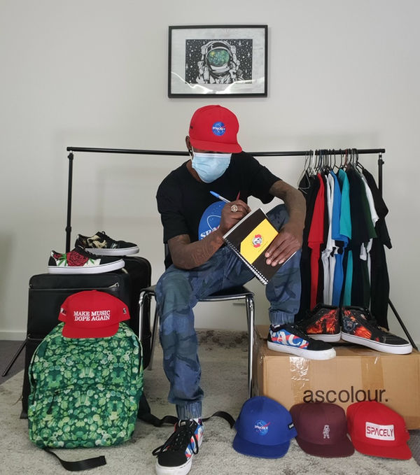 Spacely product laid out — caps, tees, backpack and shoe boxes