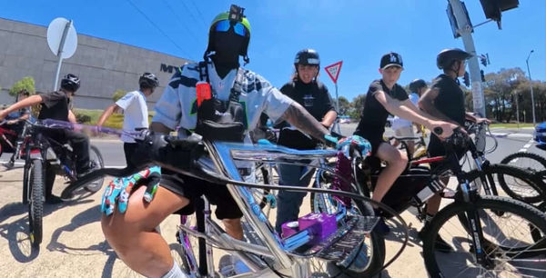 Riders lined up along a suburban road